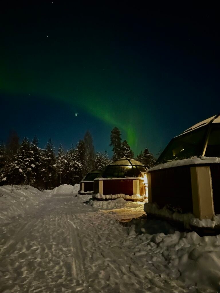 Igloo innevati a Rovaniemi illuminati dall’aurora boreale in Lapponia finlandese